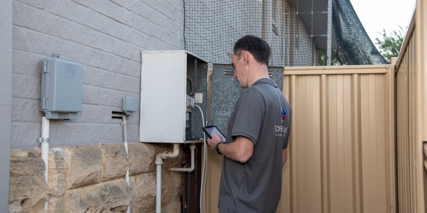 Gas Fitter Ashley from Townend Plumbing & Gas checking a gas meter with a diagnostic tablet